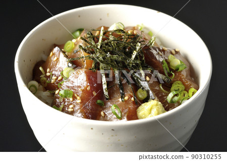 Photographed a bowl of pickled yellowtail with chopped seaweed, all-purpose greentail, and wasabi on a black background 90310255