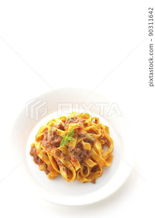 A bird's-eye view of Bolognese, which is often entwined with flat pasta fitcine and tomato sauce, on a white background. 90311642