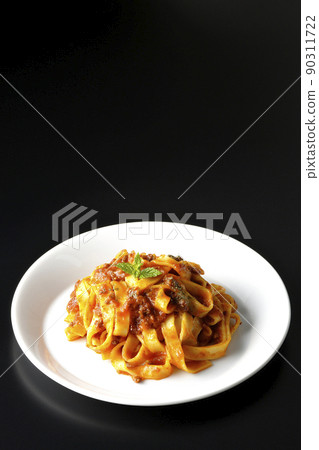 肉醬配意大利面和番茄醬，通常在黑色背景中交織在一起 90311722