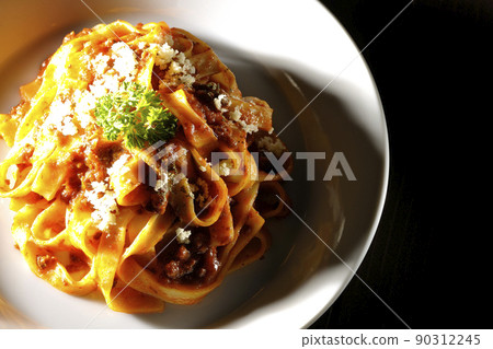A bird's-eye view of Parmesan cheese on Bolognese, which is often entwined with flat pasta fitcine and tomato sauce. A bird's-eye view of Parmesan cheese on Bolognese, which is often entwined with flat pasta fitcine and tomato sauce. 90312245