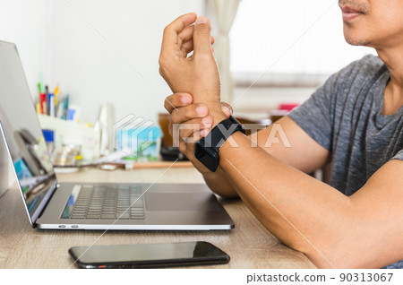 Man felt his wrist hurt while woking with laptop at home. 90313067