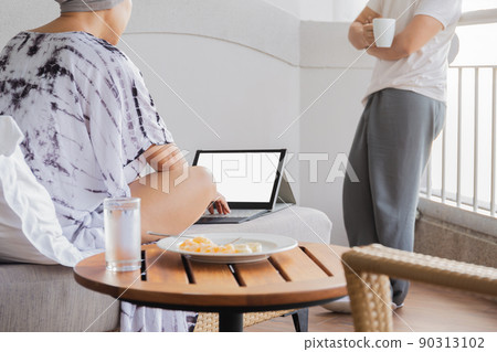 Woman working on vacation behind a laptop with a ocean view. Woman working on vacation behind a laptop with a ocean view. 90313102