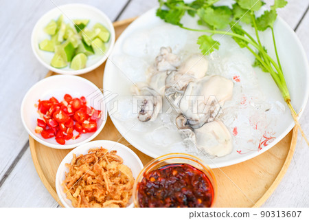 seafood plate fresh oyster on white plate background , oyster on ice with lemon lime chili sauce fried onion and seafood sauce Thai food seafood plate fresh oyster on white plate background , oyster on ice with lemon lime chili sauce fried onion and seafood sauce Thai food 90313607