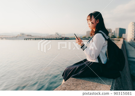 Schoolgirl in uniform and beautiful sunset sky Schoolgirl in uniform and beautiful sunset sky 90315081