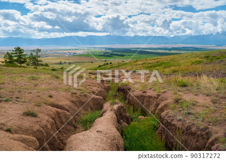 Soil erosion, deep ravine in the distance. Scenic view to colorful unusual relief. Picturesque gorge in highlands. Soil erosion, deep ravine in the distance. Scenic view to colorful unusual relief. Picturesque gorge in highlands. 90317272
