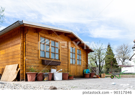 Small beautiful wooden house shed or storage hut for garden tools equipment and bicycles at backyard at beautiful american or european countryside backyard. Cozy rural yard stuff warehouse Small beautiful wooden house shed or storage hut for garden tools equipment and bicycles at backyard at beautiful american or european countryside backyard. Cozy rural yard stuff warehouse 90317846