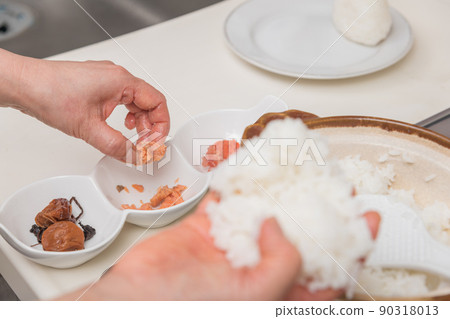[Middle housewife makes rice balls with rice cooked in a clay pot. The ingredients are salt salmon] 90318013