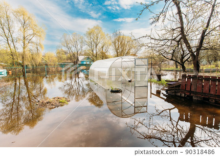 Vegetable Garden Beds In Water During Spring Flood floodwaters during natural disaster. Greenhouse Hothouse in Water deluge During A Spring Flood. inundation River 90318486
