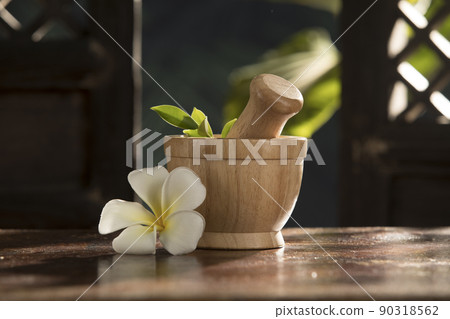 close up view of mortar and flower on green tropic back 90318562