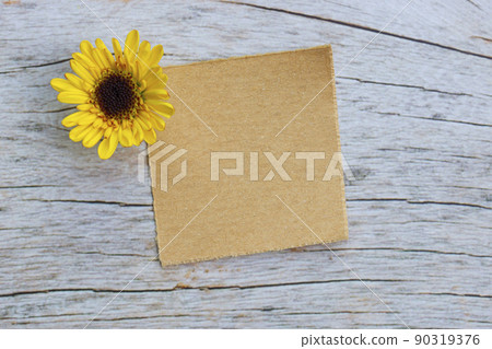 Torn brown paper on wooden surface and dahlia flower flat lay with copy space. 90319376