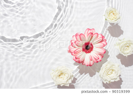 Sunny summer cosmetic background with flowers. The texture of the water surface. 90319399