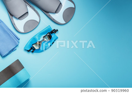 Set for training and learning to swim in the pool and open water on a blue background, top view with free space Set for training and learning to swim in the pool and open water on a blue background, top view with free space 90319960