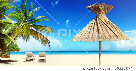 Relax on tropical beach in the sun on deck chairs under umbrella. 90322074