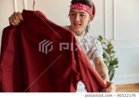 Happy stylish guy holding a new shirt after online shopping 90322176