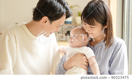 A couple looking at a baby 90323475