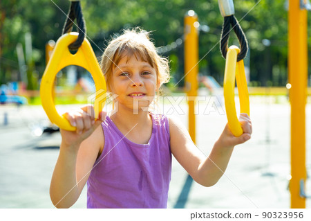 Teenager smiling girl playing on playground Teenager smiling girl playing on playground 90323956