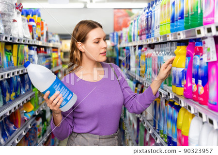Young woman buying household chemicals or laundry detergent at supermarket Young woman buying household chemicals or laundry detergent at supermarket 90323957