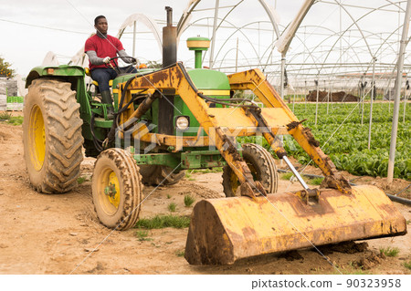 Guy driving farm tractor Guy driving farm tractor 90323958