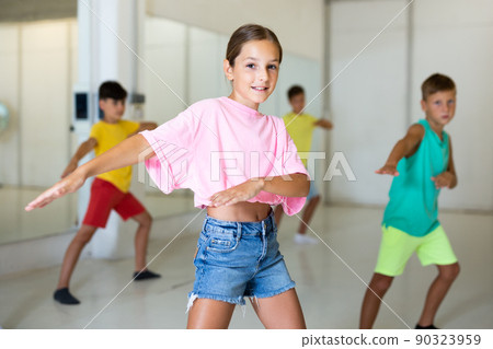 Young girls and boys performing modern dance in studio Young girls and boys performing modern dance in studio 90323959