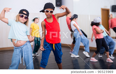 Preteen white girl and afro boy breakdancers in dance studio Preteen white girl and afro boy breakdancers in dance studio 90323969