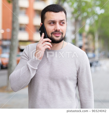 Portrait of stylish tourist in light clothes walking around city with suitcase 90324042