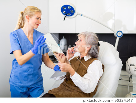 Cosmetologist and senior woman during doctor's appointment 90324147
