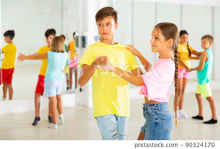 Preteen children learning to dance waltz in pairs in choreography class 90324170