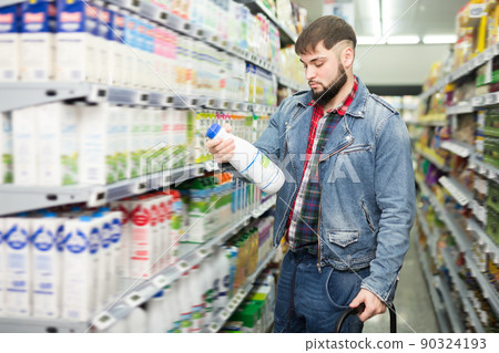 Focused guy choosing fresh organic dairy products Focused guy choosing fresh organic dairy products 90324193