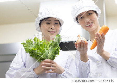 A woman wearing a lab coat and making a meal 90326319