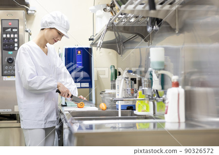 A woman wearing a lab coat and making a meal A woman wearing a lab coat and making a meal 90326572