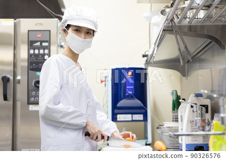 A woman wearing a lab coat and making a meal A woman wearing a lab coat and making a meal 90326576