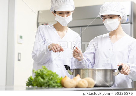 A woman wearing a lab coat and making a meal 90326579