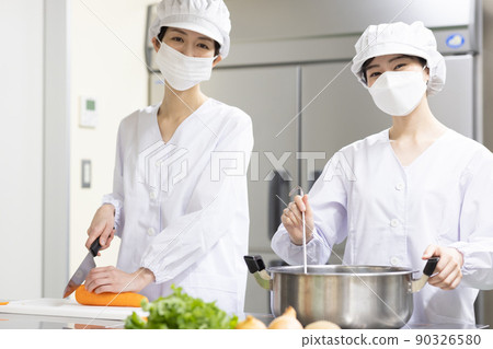 A woman wearing a lab coat and making a meal 90326580