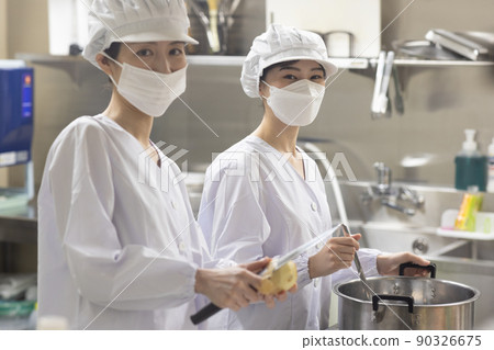 A woman wearing a lab coat and making a meal 90326675