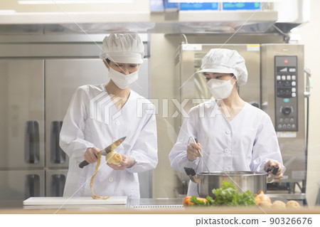 A woman wearing a lab coat and making a meal 90326676