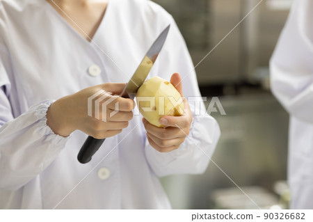 A woman wearing a lab coat and making a meal A woman wearing a lab coat and making a meal 90326682