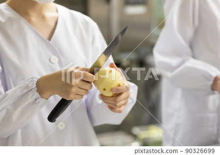 A woman wearing a lab coat and making a meal A woman wearing a lab coat and making a meal 90326699