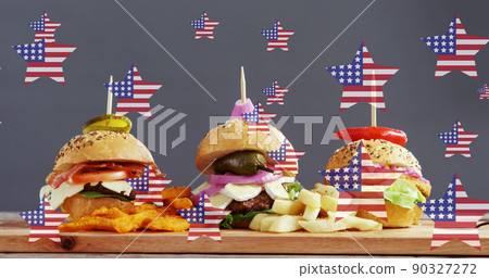 Image of stars with flag of usa over burgers lying on wooden board Image of stars with flag of usa over burgers lying on wooden board 90327272
