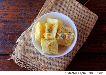 boiled and fried cassava (mandioca) in ceramic bowl on rustic wooden table boiled and fried cassava (mandioca) in ceramic bowl on rustic wooden table 90327304