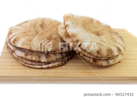 Pita bread isolated on white background in wooden spatula. Traditional food of Arabic cuisine Pita bread isolated on white background in wooden spatula. Traditional food of Arabic cuisine 90327432