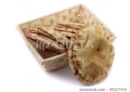 Pita bread isolated on white background in the breakfast basket. Traditional food of Arabic cuisine Pita bread isolated on white background in the breakfast basket. Traditional food of Arabic cuisine 90327433