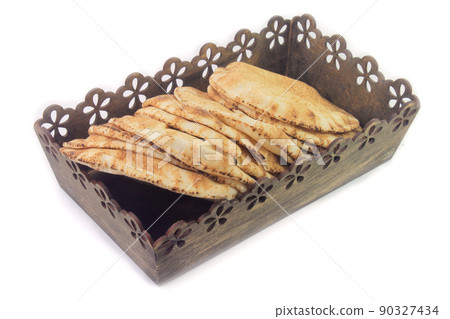 Pita bread isolated on white background in the breakfast basket. Traditional food of Arabic cuisine Pita bread isolated on white background in the breakfast basket. Traditional food of Arabic cuisine 90327434