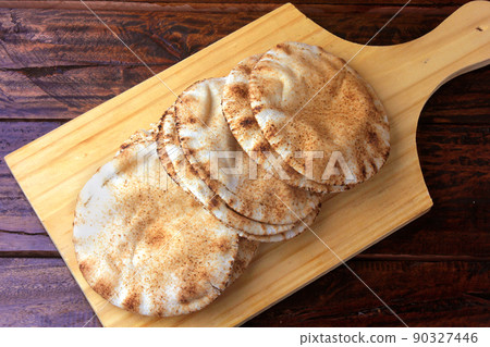 Pita bread isolated on wooden spatula coming out of the oven. Traditional food of Arabic cuisine Pita bread isolated on wooden spatula coming out of the oven. Traditional food of Arabic cuisine 90327446