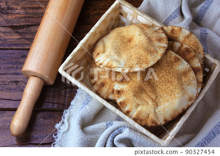 Pita bread isolated on white background in the breakfast basket, on rustic wooden table.Traditional food of Arabic cuisine Pita bread isolated on white background in the breakfast basket, on rustic wooden table.Traditional food of Arabic cuisine 90327454