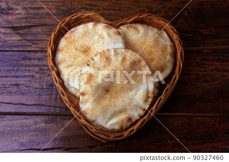 Pita bread isolated on white background in the breakfast basket, on rustic wooden table.Traditional food of Arabic cuisine 90327460