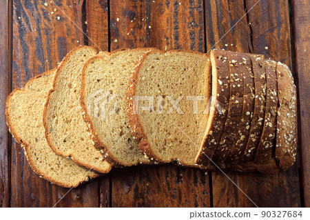 Wholegrain sliced organic bread composed of oats and flax seeds on wooden table. Healthy Diet 90327684