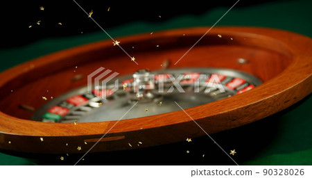 Composite image of multiple golden star icons falling against close up of russian roulette spinning 90328026
