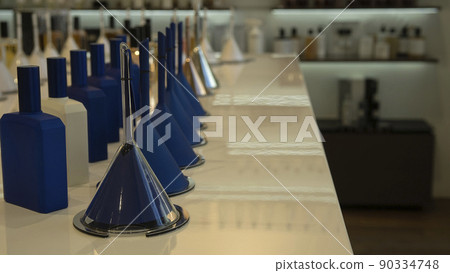 Perfume bottles and funnels with fragrance on the counter in a luxury store 90334748