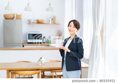 A middle-class business woman in the real estate industry with a calculator 90335452