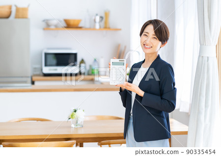 A middle-class business woman in the real estate industry with a calculator 90335454